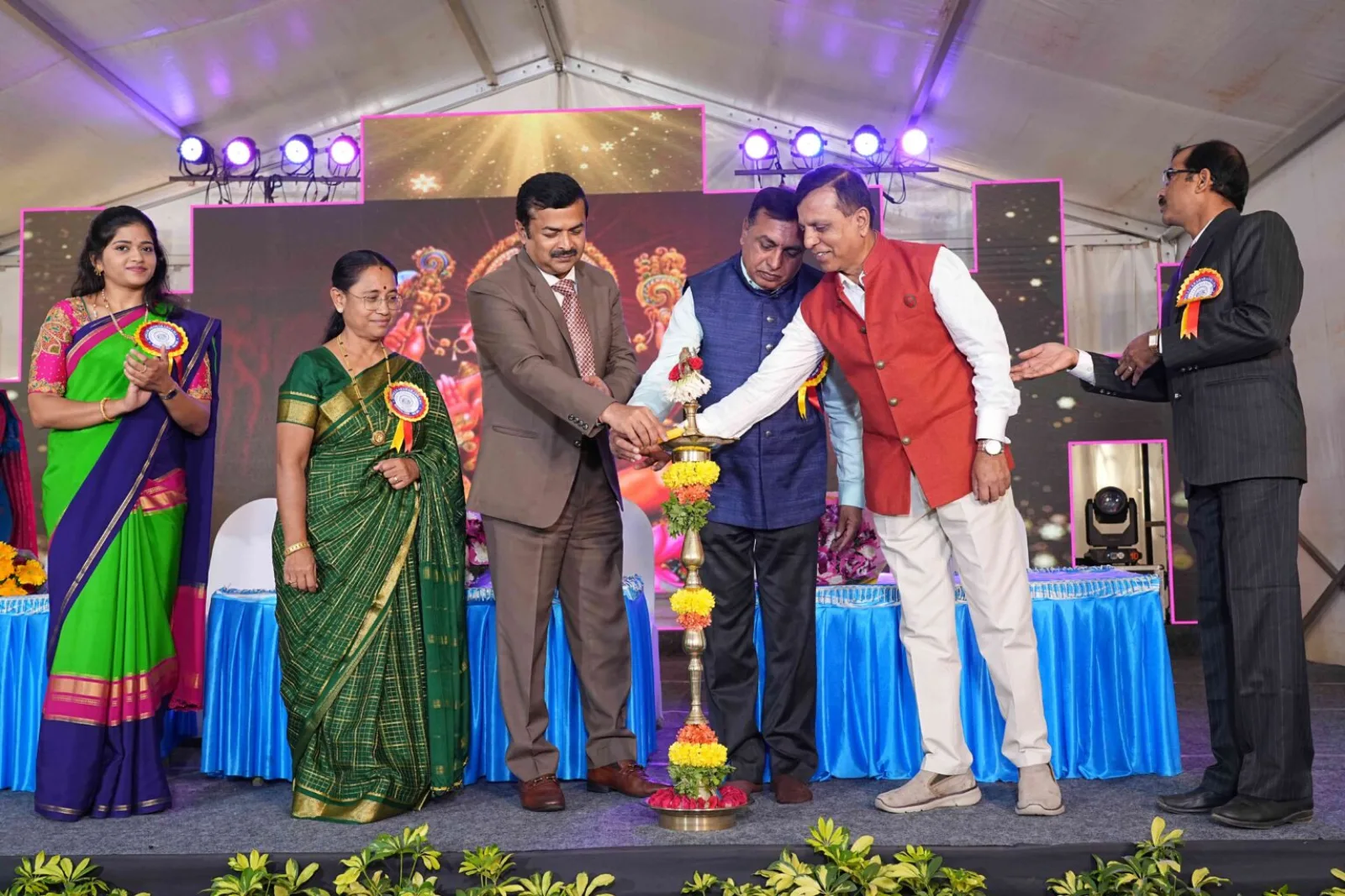 Management presenting a trophy to a guest on stage, with staff members in formal attire