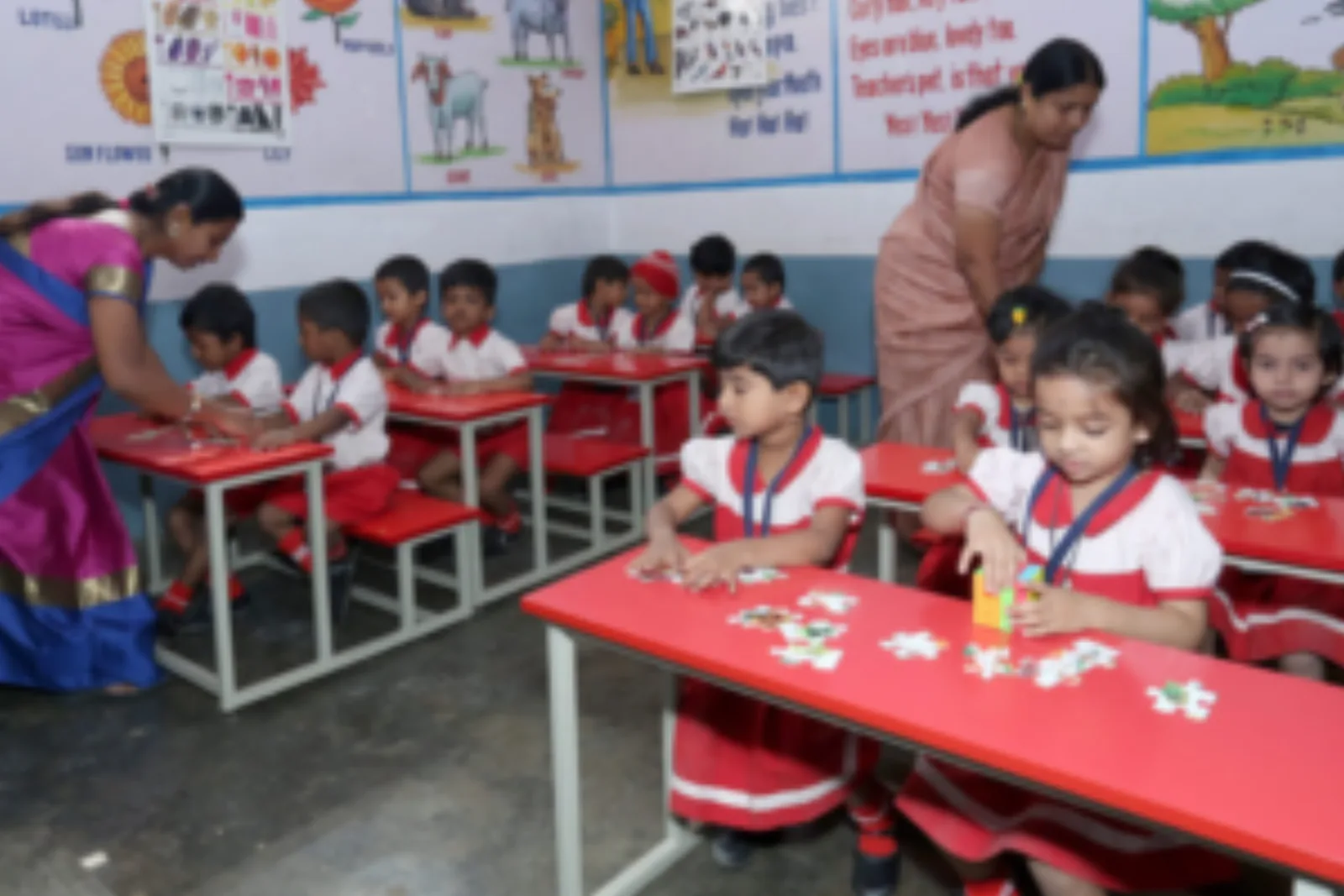A teacher helping young children with a hands-on activity at a classroom table