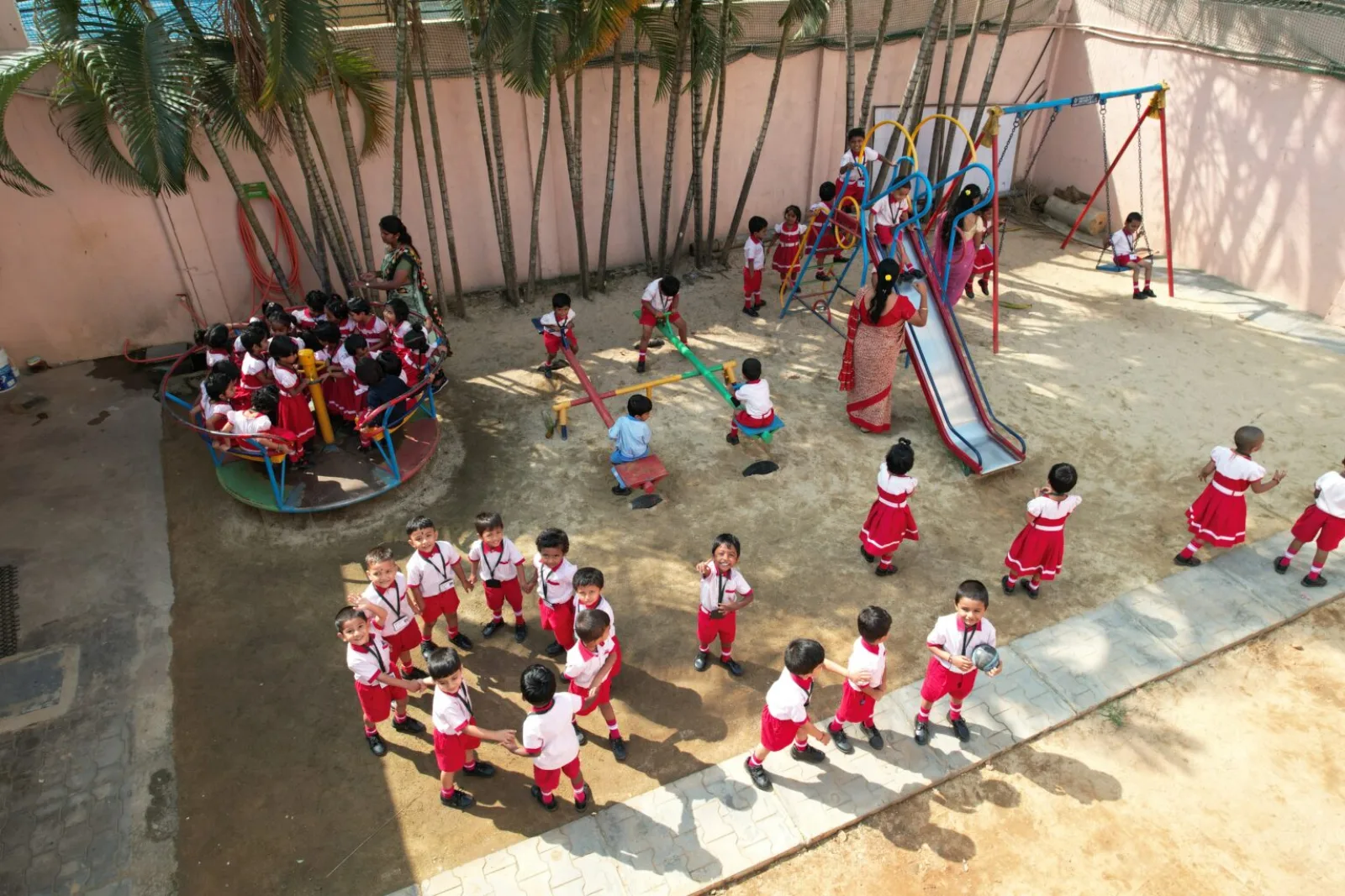 Young children playing on outdoor play equipment on the school playground