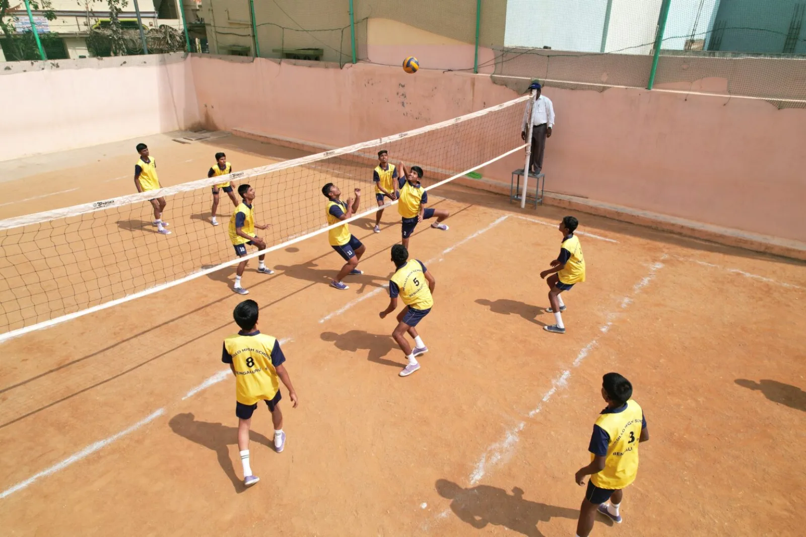 Students playing volleyball on an outdoor court