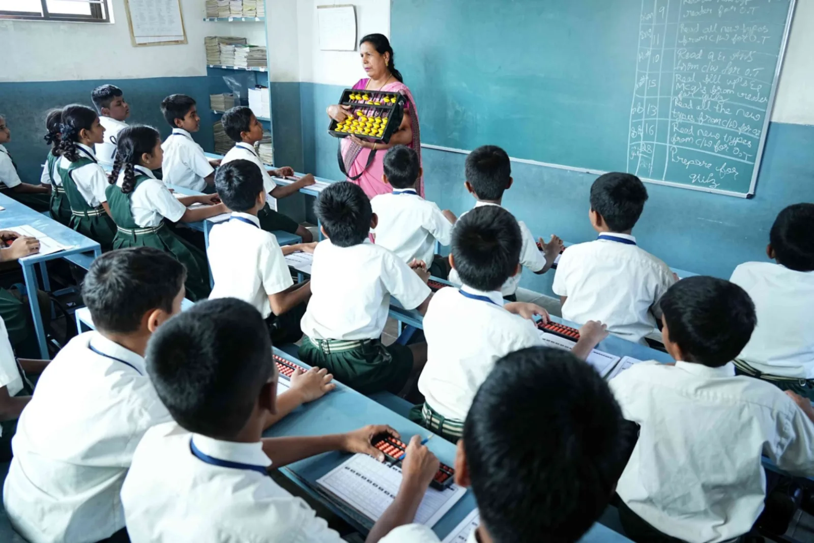 Students seated at their desks writing during a classroom activity