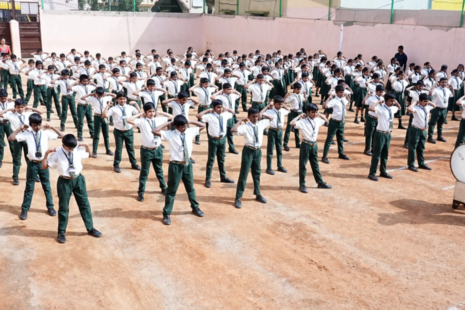A large group of students in uniform performing a physical training formation outdoors