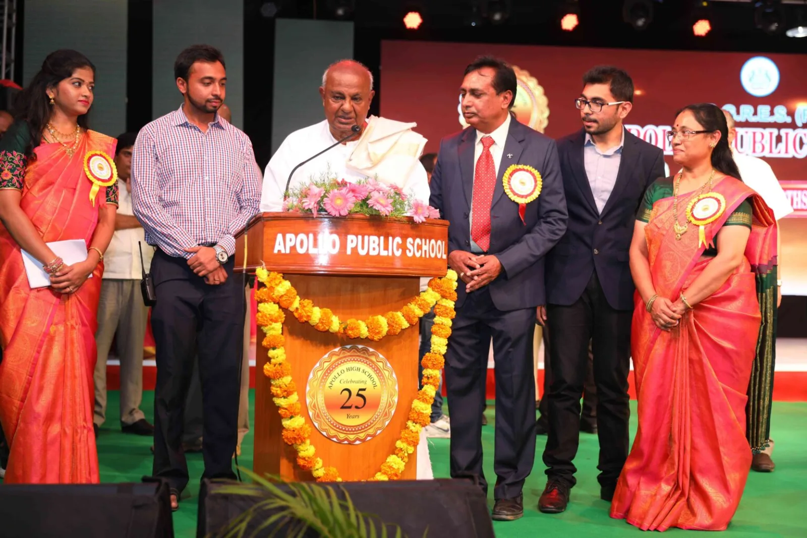School management and guests on stage presenting an award during a felicitation ceremony